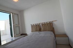 una camera da letto con un letto e una grande finestra di Casa Nisea a Santa Cesarea Terme a Santa Cesarea Terme