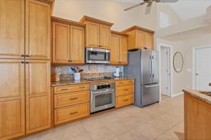 a kitchen with wooden cabinets and stainless steel appliances at 120 Great Isaac in Punta Gorda