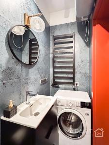 uma casa de banho com uma máquina de lavar roupa e um lavatório em Biskupia Central Apartment em Gdansk
