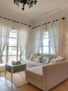 a living room with a white couch and windows at Poros Pine View in Poros