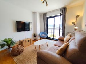 una sala de estar con un sofá y una mesa en Portbeach, en Viveiro