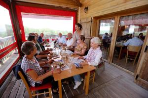 a group of people sitting at a table in a restaurant at Au Doubs Repos in Vorges-les-Pins