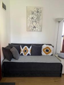 a couch with pillows on it in a living room at Apartman Zlatibor “LOLA” in Zlatibor