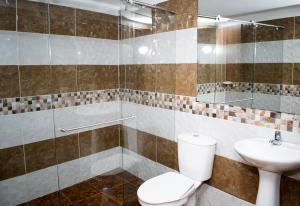 a bathroom with a toilet and a sink at Hotel Los Angeles in Calarcá