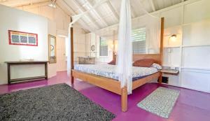 a bedroom with a bed and a purple floor at Feather's Guesthouse in San Pedro