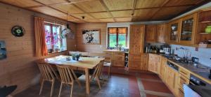 a kitchen with a wooden table and some chairs at Ferienhof Rindalphorn mit Sauna in ländlicher Idylle in Missen-Wilhams