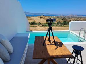 a camera on a tripod on a table next to a pool at Ariadne's Crown Suites Astro Concept Luxury in Vívlos