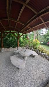 a patio with a stone table under a roof at Casitas Del Rio Riverfront Jungle Beach Vacation in Uvita