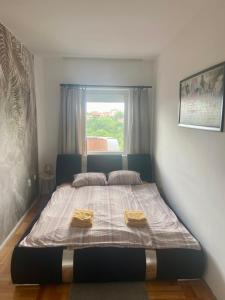 a bedroom with a bed with two towels on it at City view & pool apartment in Niš +17 photos
