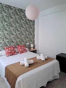 a bedroom with a large bed with white sheets and red pillows at Chloe37 in Benidorm