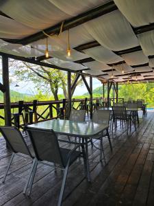 a patio with tables and chairs on a deck at Sunrise Glamping Retreat in Galeşu