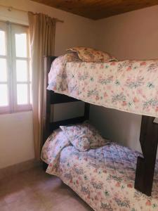 1 dormitorio con 2 literas y ventana en Cabañas el Bosque de los Milicos en Uspallata
