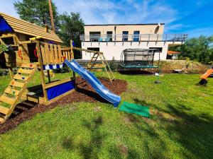 a playground with a slide in a yard at Tiny Kozma Apartment in Bodensdorf