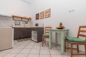 Dora's Apartments في لاغاناس: مطبخ مع طاولة وكرسيين وكاونتر