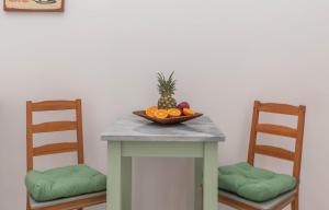 Dora's Apartments في لاغاناس: طاولة عليها صحن فاكهة مع كرسيين