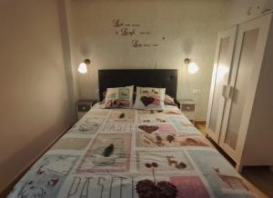 a bedroom with a bed with a quilt on it at Serendipia Apartamentos 1 in Logroño
