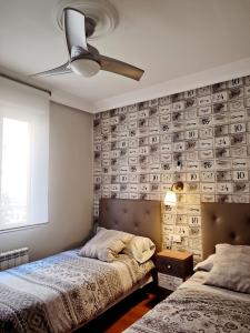 1 dormitorio con 2 camas y ventilador de techo en Serendipia Apartamentos 1, en Logroño