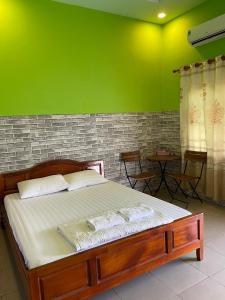 にあるNHÀ NGHỉ HẬU NHIの緑の壁のベッドルーム1室