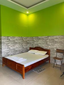 にあるNHÀ NGHỉ HẬU NHIの緑の壁のドミトリールーム(ベッド1台)