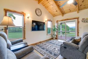 sala de estar con 2 sillas y reloj en la pared en Newport Retreat 12 Mi to Great Smoky Mountains!, en Newport