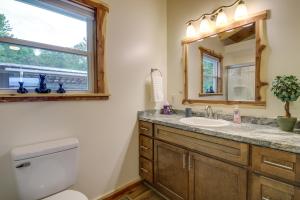 Un baño con inodoro, lavabo y espejo. en Newport Retreat 12 Mi to Great Smoky Mountains!, en Newport 17 fotos más