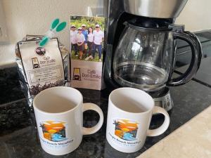 due tazze di caffè su un bancone accanto a un frullatore di Casitas Del Rio Riverfront Jungle Beach Vacation a Uvita