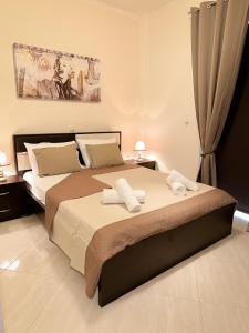 トロにあるSun n' Salt I Apartmentのタオルが敷かれた大きなベッドのある寝室