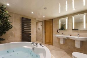 y un baño grande con bañera y 2 lavabos. en Aphrodites Group en Bowness-on-Windermere