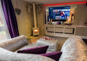 een woonkamer met 2 banken en een groot televisiescherm bij Aphrodites Group in Bowness-on-Windermere