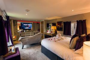 1 dormitorio con 1 cama grande y TV en Aphrodites Group, en Bowness-on-Windermere