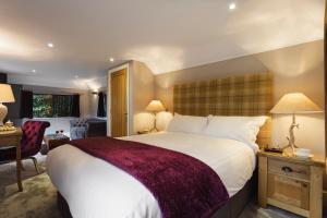 ein Schlafzimmer mit einem großen Bett und ein Wohnzimmer in der Unterkunft Aphrodites Group in Bowness-on-Windermere