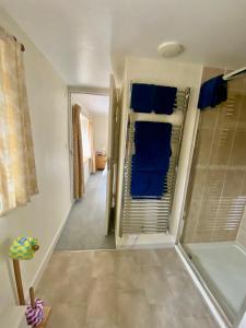 uma casa de banho com uma cabina de duche ao nível do chão e toalhas azuis em Lynwood House Bed and Breakfast em Tregoney
