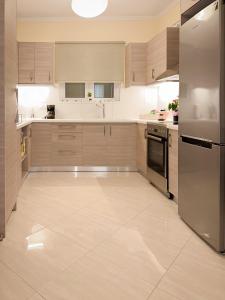 トロにあるSun n' Salt I Apartmentの大きなキッチン(木製キャビネット、ステンレス製の電化製品付)