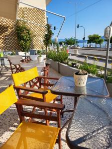 ASTIR COSY LIVING HOTEL في Áyios Konstandínos: فناء به طاولات وكراسي وطاولة وكراسي