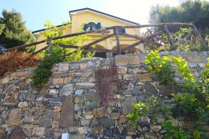 una pared de piedra con una casa en el fondo en Antico Portale en Ascea