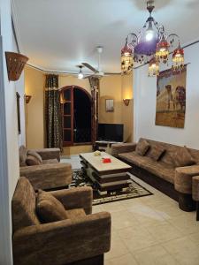 a living room with couches and a table in it at Egypt Villa Garden in Luxor