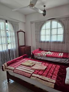 a bedroom with two beds and a mirror and windows at Egypt Villa Garden in Luxor +43 photos