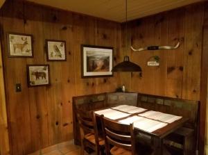 a wooden dining room with a table and chairs at 1948 Cottage with today's amenities in Bass Lake Annex
