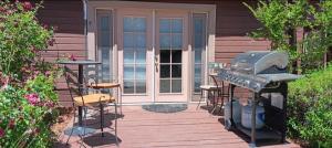 a patio with a grill and stools in front of a house at 1948 Cottage with today's amenities in Bass Lake Annex +13 photos