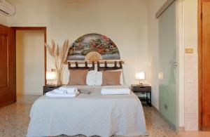 una camera da letto con un grande letto e un dipinto sul muro di LE 7 CALLE a Pisa