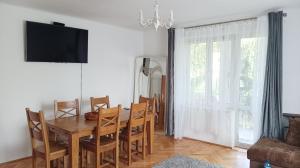 jadalnia ze stołem, krzesłami i telewizorem w obiekcie Hoffberg Apartment w przyziemiu (ground floor) w mieście Lublin