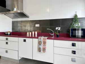 cocina con armarios blancos y encimera roja en Brisa Marina, en Las Negras 41 fotos más
