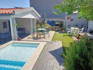 a backyard with a swimming pool and a table and chairs at Mata Beach Caparica in Costa da Caparica