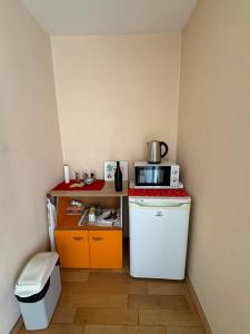 a small kitchen with a refrigerator and a microwave at Дом за гости ГЕРГАНА in Pleven