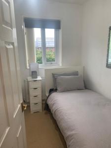 ein kleines Schlafzimmer mit einem Bett und einem Fenster in der Unterkunft Comfort Rooms in Wigan