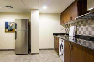 Il comprend une cuisine équipée d'un réfrigérateur en acier inoxydable. dans l'établissement Gman apartment, à Amman