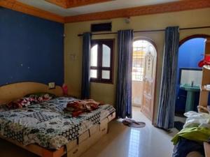 a bedroom with a bed with blue walls and a window at Gman apartment in Amman