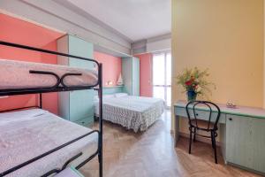 a room with two bunk beds and a desk with a table at Hotel Sabbia d'Oro in Rimini