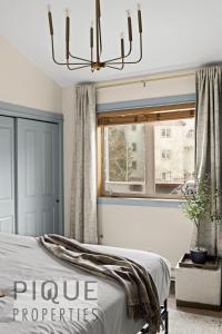 a bedroom with a bed and a window at Mountain Loft Retreat, Heated Pool & Hot Tub, UG Parking, Balcony, WiFi! in Canmore
