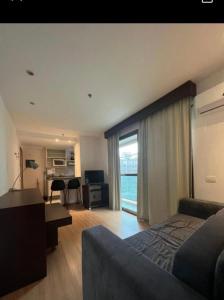 a hotel room with a bed and a desk and a living room at Premium Copacabana - Rio de Janeiro in Rio de Janeiro